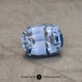 A close-up image of a stunning 2.14-carat Robin's Egg Blue Montana sapphire gemstone on a textured, neutral-colored surface. The cushion-cut gemstone exhibits brilliant facets that reflect light beautifully. The text "Earth's Treasury" is visible at the bottom of the image.