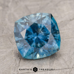 A blue gemstone, intricately faceted, is showcased on a textured grey surface with the text "MS2229" visible at the bottom of the image.