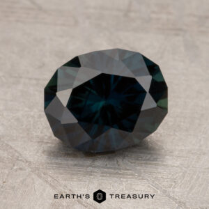 A polished 2.17-Carat Australian Sapphire with facets reflecting light, set on a textured surface. The text "Earth's Treasury" is underneath the gemstone.