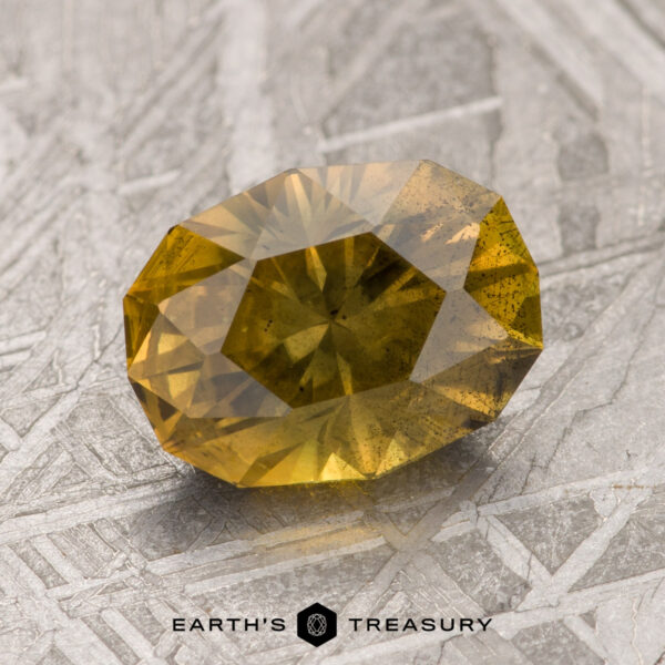 A 2.31-carat Australian sapphire gemstone placed on a textured grey surface with the text "Earth's Treasury" at the bottom.