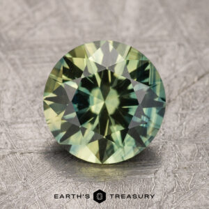 A 2.37-carat Australian sapphire is displayed on a textured surface with the words "Earth's Treasury" below it.