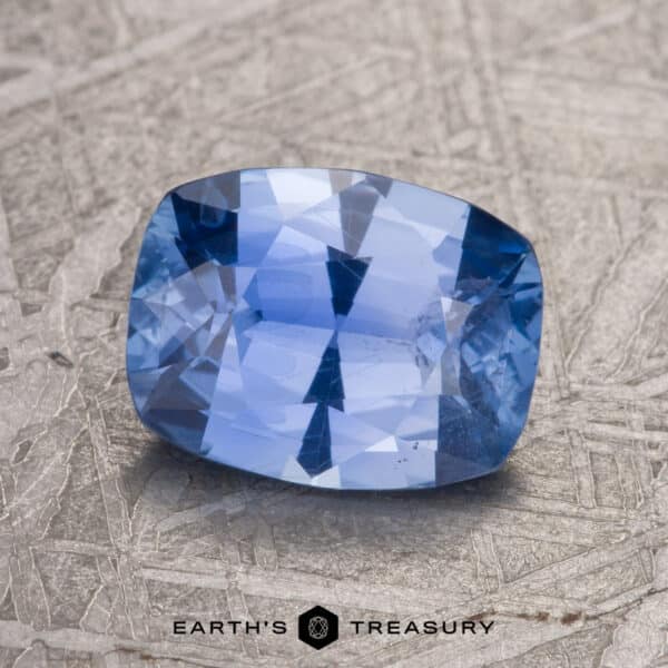 A 2.26-Carat Sky Blue Ceylon Sapphire is displayed on a textured surface.