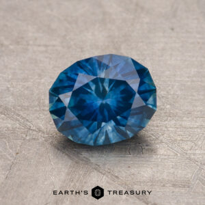 A 1.29-carat Montana sapphire (heated) displayed on a textured surface.