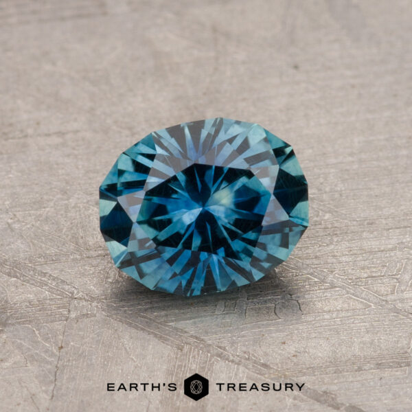 A 1.19-carat Montana sapphire (heated) with intricate faceting sits on a textured surface.