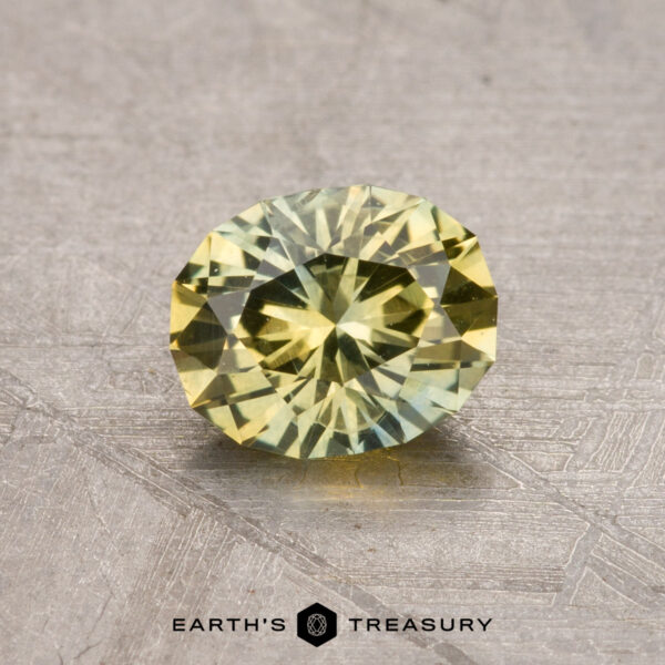 A round, yellow gemstone with a faceted cut is showcased on a textured surface, accompanied by the inscription "Earth's Treasury: 0.93-Carat Montana Sapphire (Heated)" at the bottom.