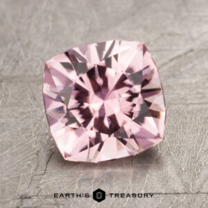 A square-cut pink gemstone with intricate facets, displayed on a textured gray surface, is paired with the text "Earth's Treasury," accompanied by the model identifier "ET1600" at the bottom.